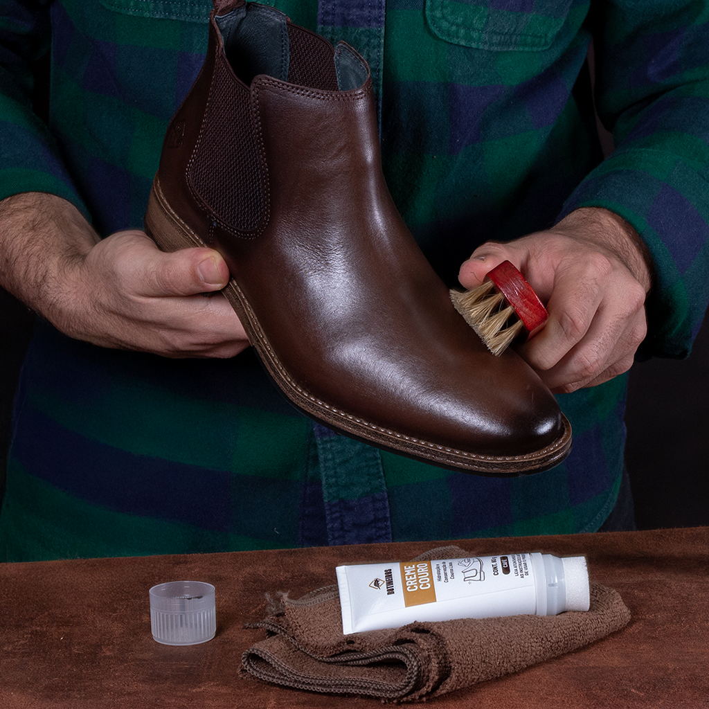 Hidratação do couro: Produto sendo aplicado na bota
