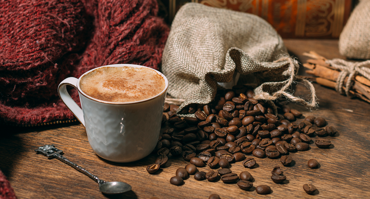 Xícara de café fumegante com grãos de café da Alta Mogiana